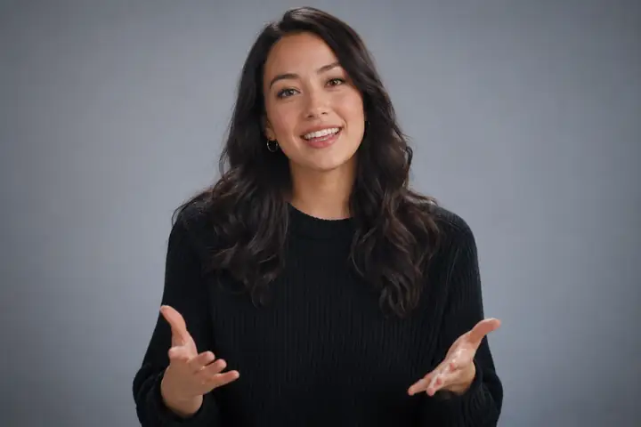 Polished studio host speaking naturally against a neutral background